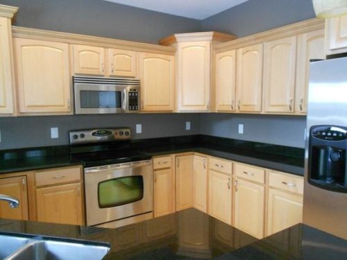 Dark Granite Countertops with Light cabinets and gray wall